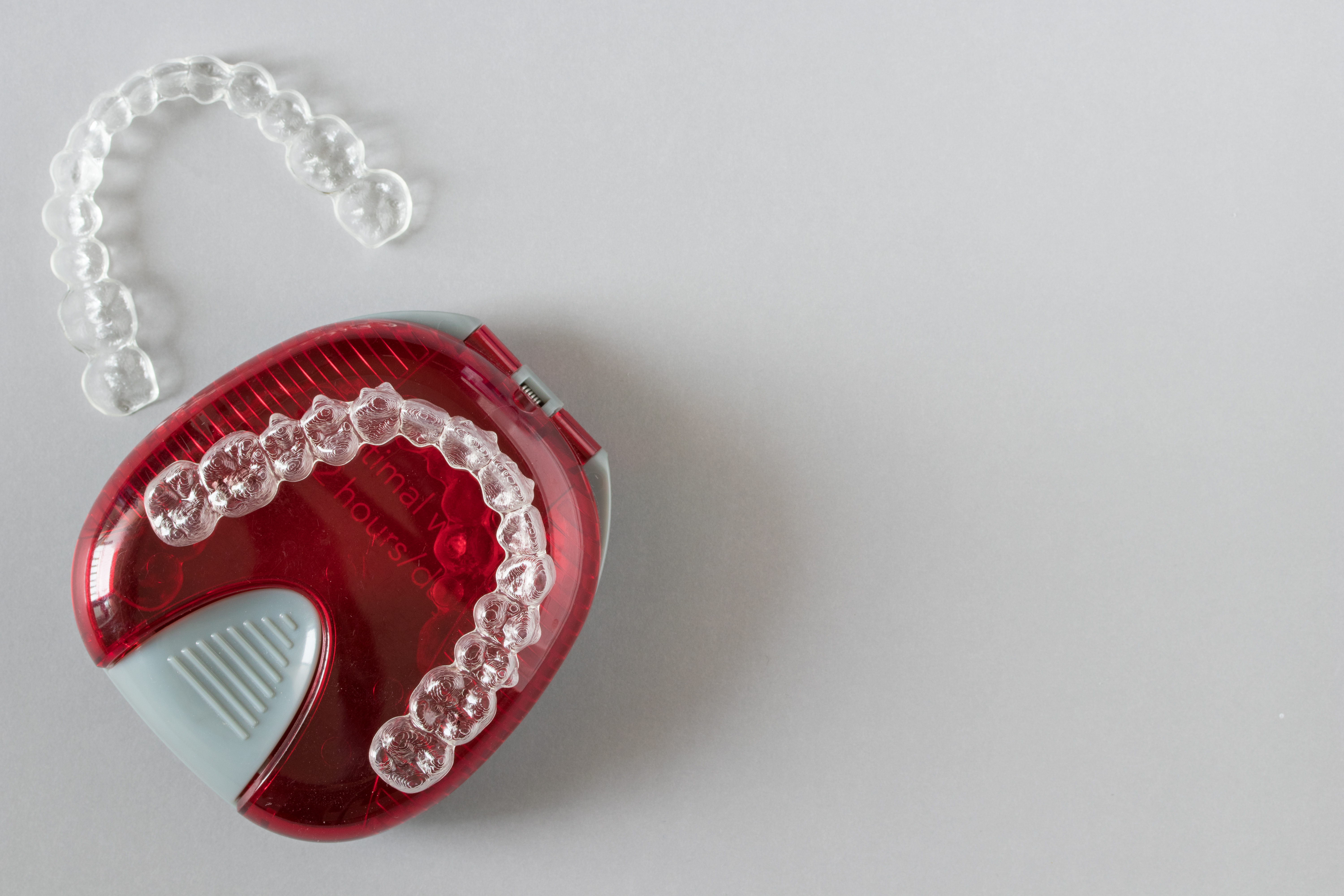 Top view of invisalign braces or invisible retainers on grey background, new orthodontic equipment